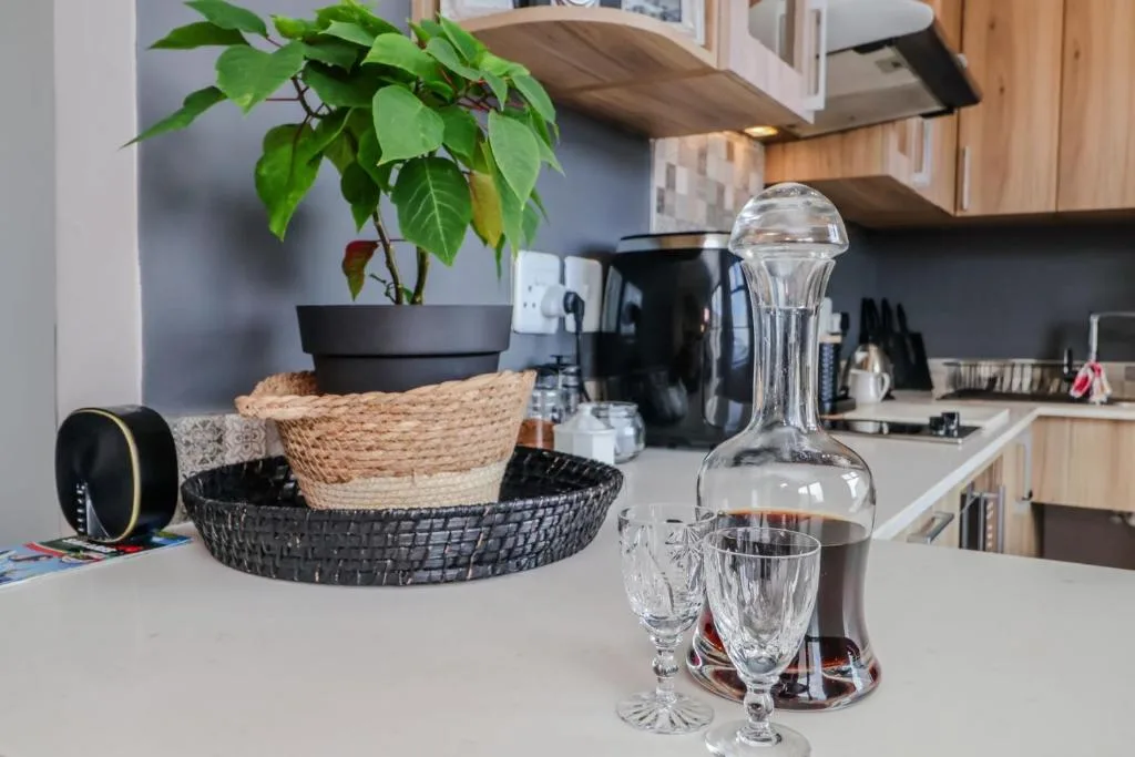 Modern kitchen counter with plant, glassware, and decorative baskets