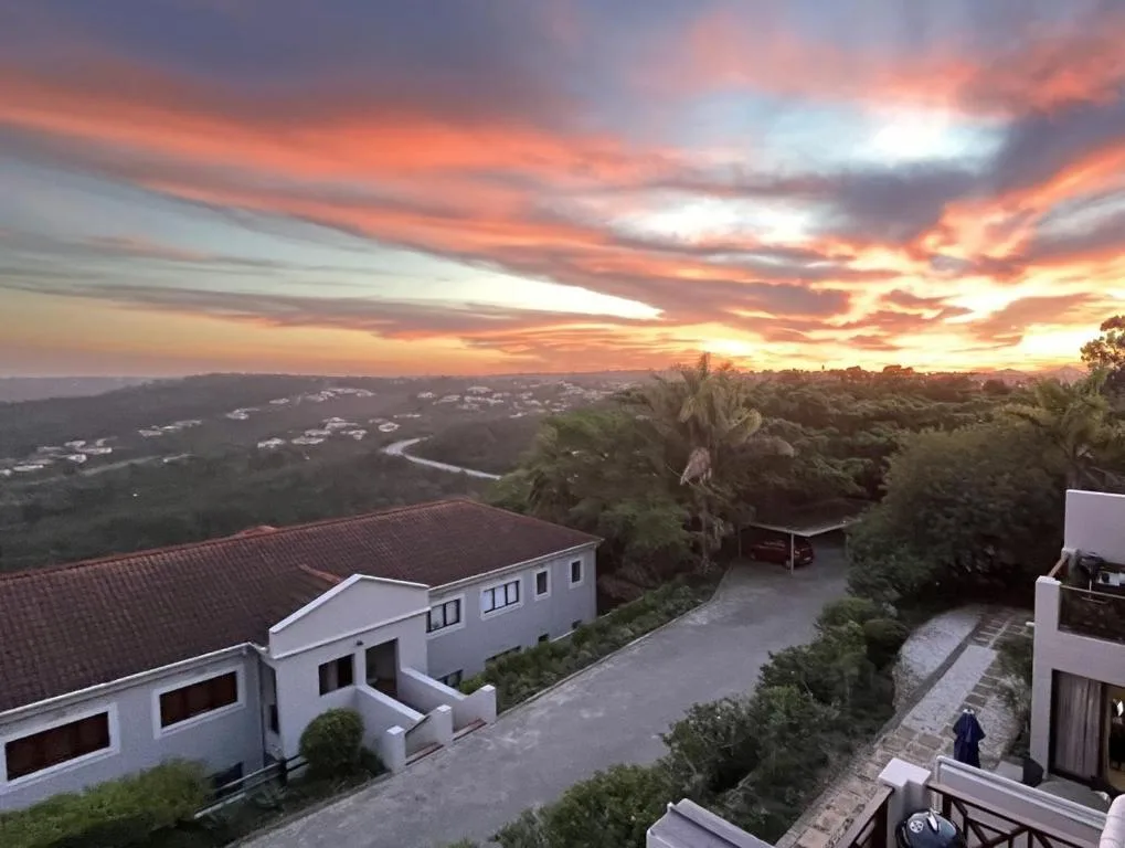 Stunning sunset over lagoon and forested landscape from hillside property