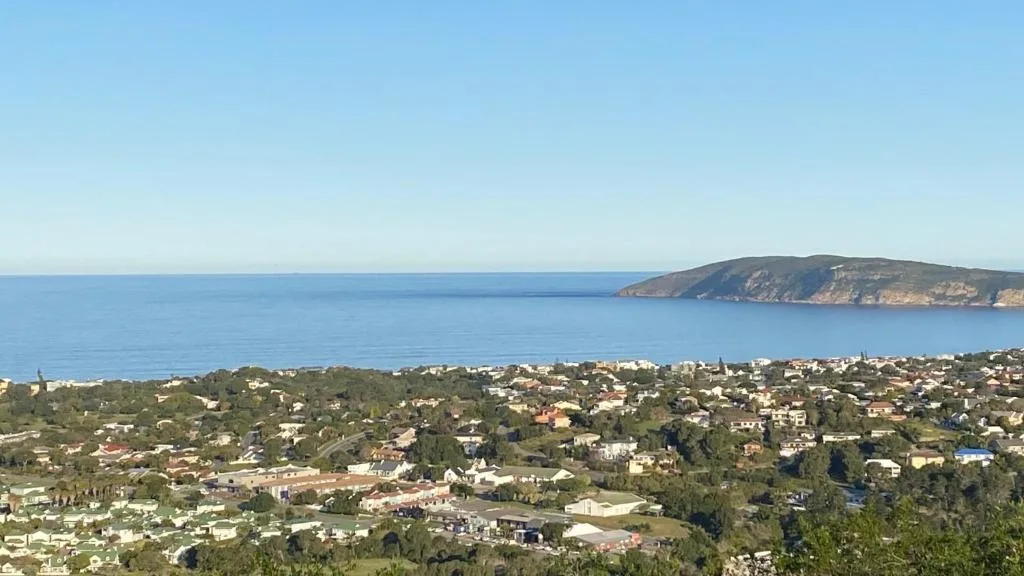 Panoramic coastal view of Plettenberg Bay with ocean, headland, and town below