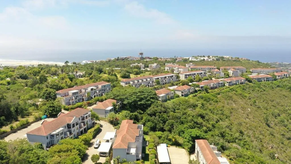 Aerial view of Plettenberg Bay town nestled between lush green hills and ocean