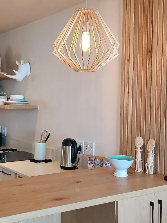 Modern wooden pendant light above kitchen counter with decor accents