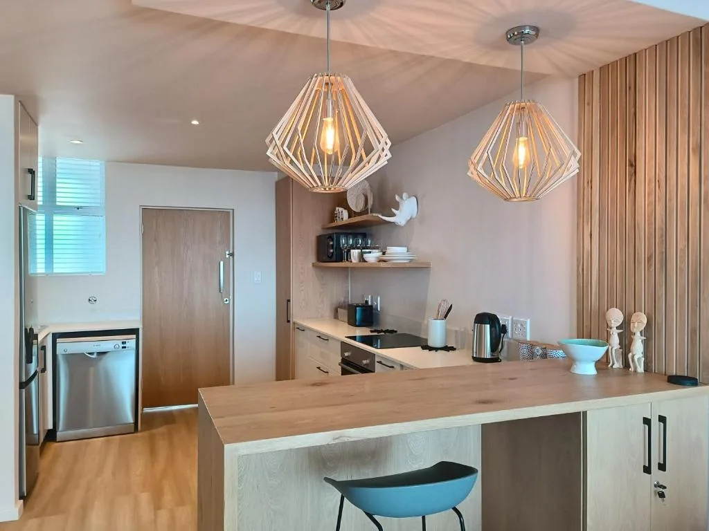 Modern kitchen with wooden island, pendant lights, stainless steel appliances
