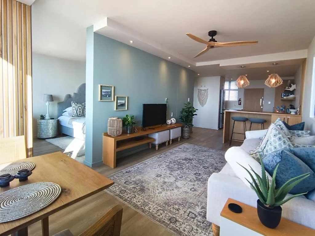 Open-plan lounge with TV, comfortable seating, and modern décor throughout