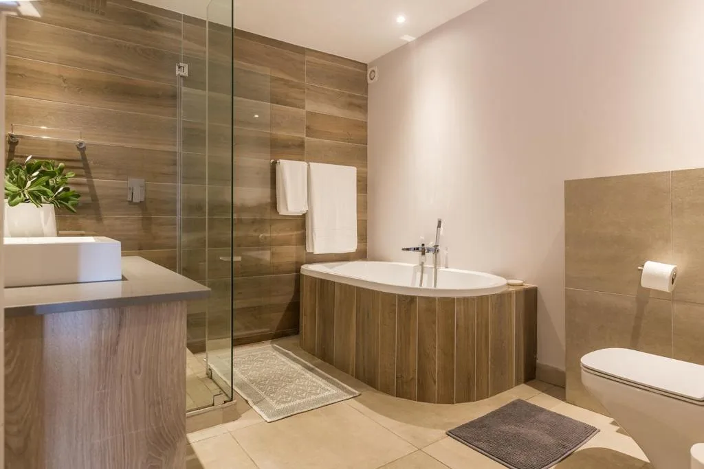 Modern bathroom with freestanding wooden tub, walk-in shower, and vanity