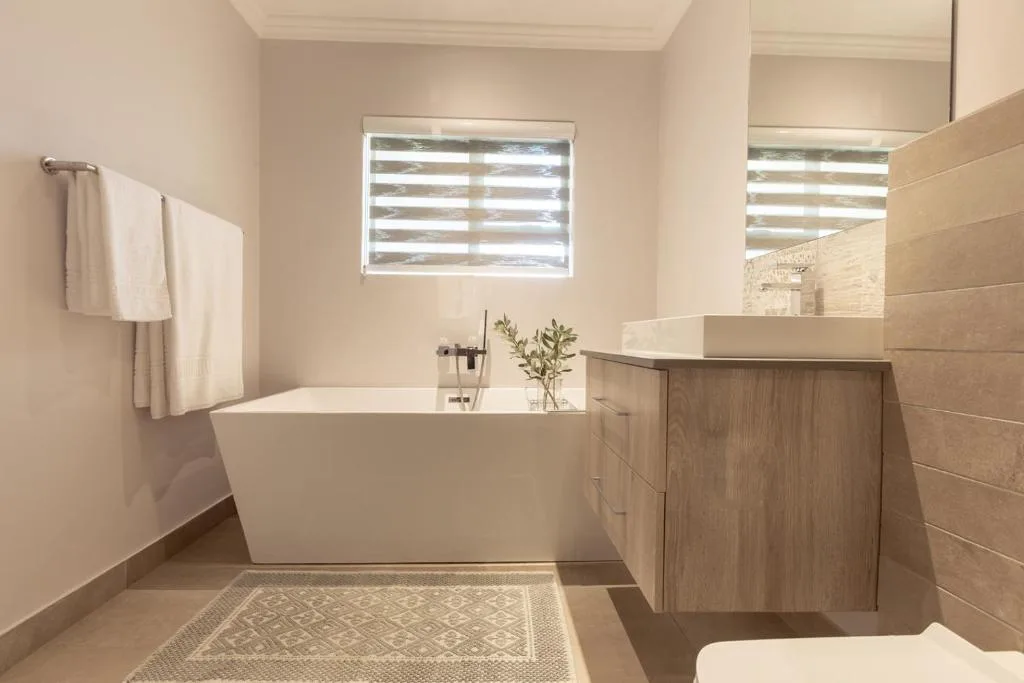 Modern bathroom with freestanding white bathtub and wooden vanity
