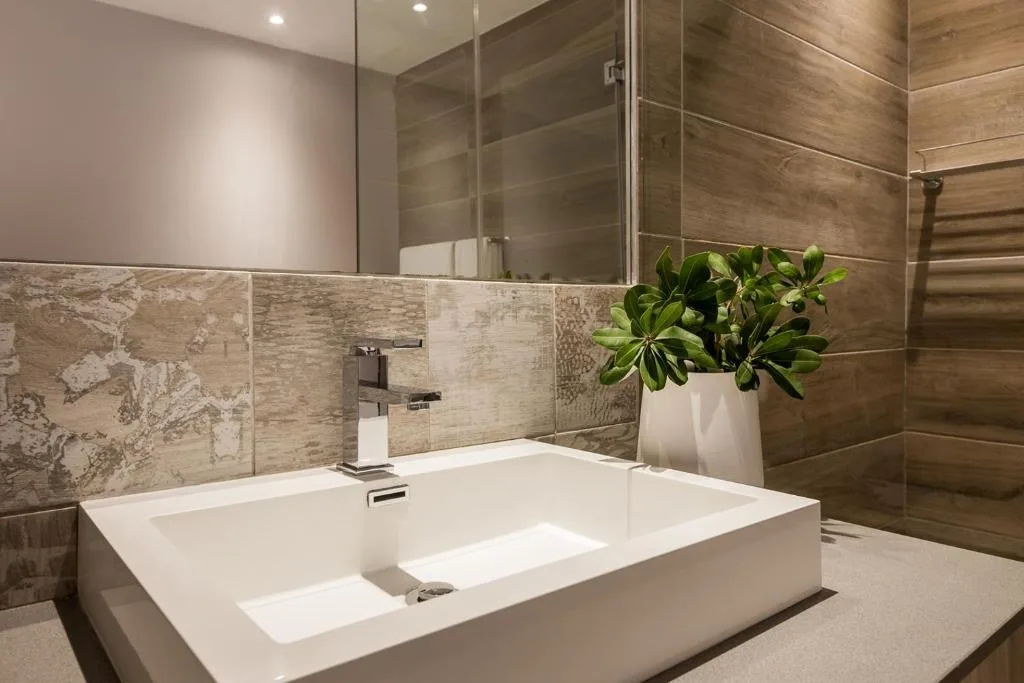 Modern bathroom with dual basin vanity, glass shower enclosure, and wooden tile accents