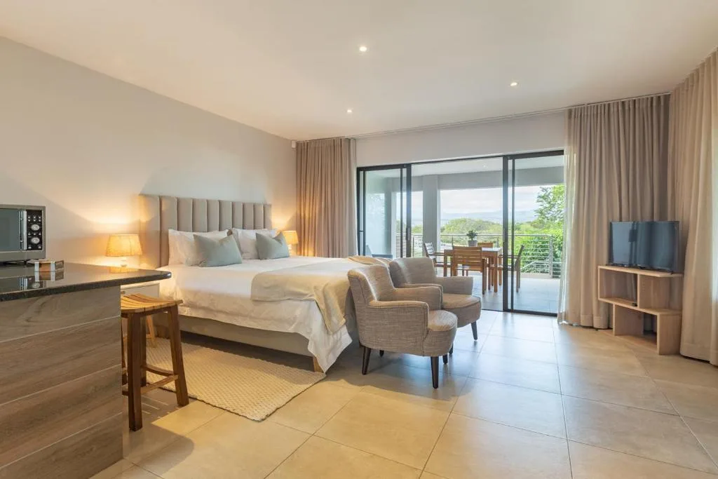 Spacious bedroom with king bed, upholstered headboard, and sliding doors to deck