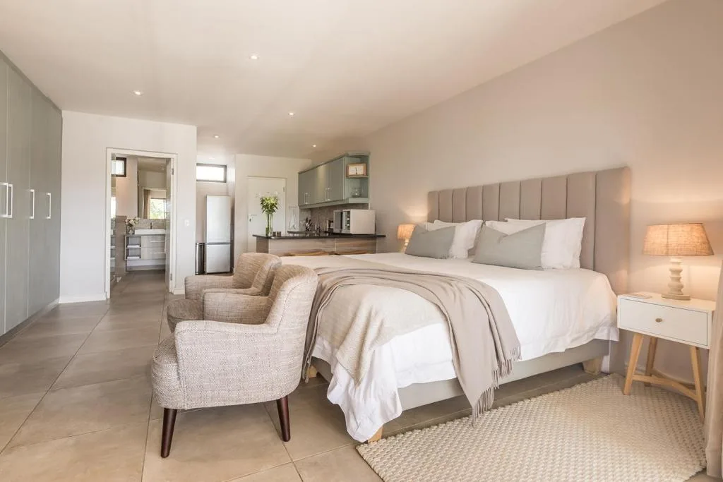 Spacious master bedroom with ensuite bathroom and kitchenette visible