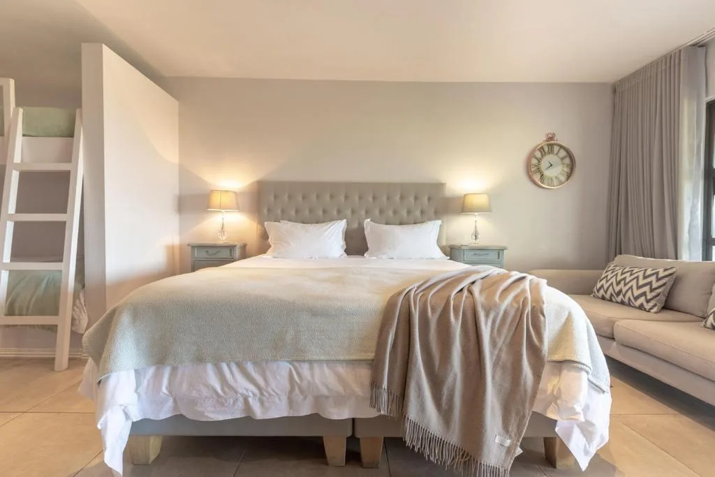 Spacious master bedroom with upholstered headboard and white bedding