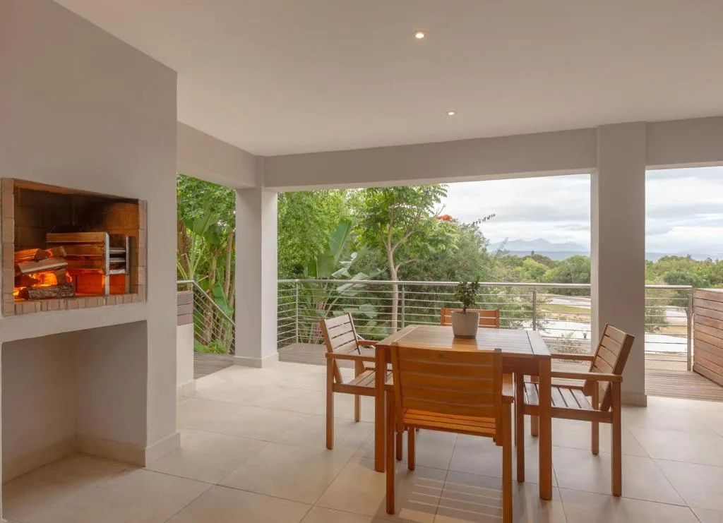 Modern covered deck with dining table overlooking mountains and lagoon views