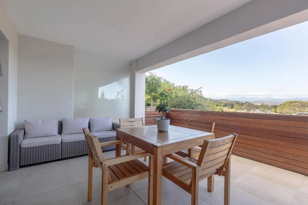 Covered deck with dining table, seating, and mountain views
