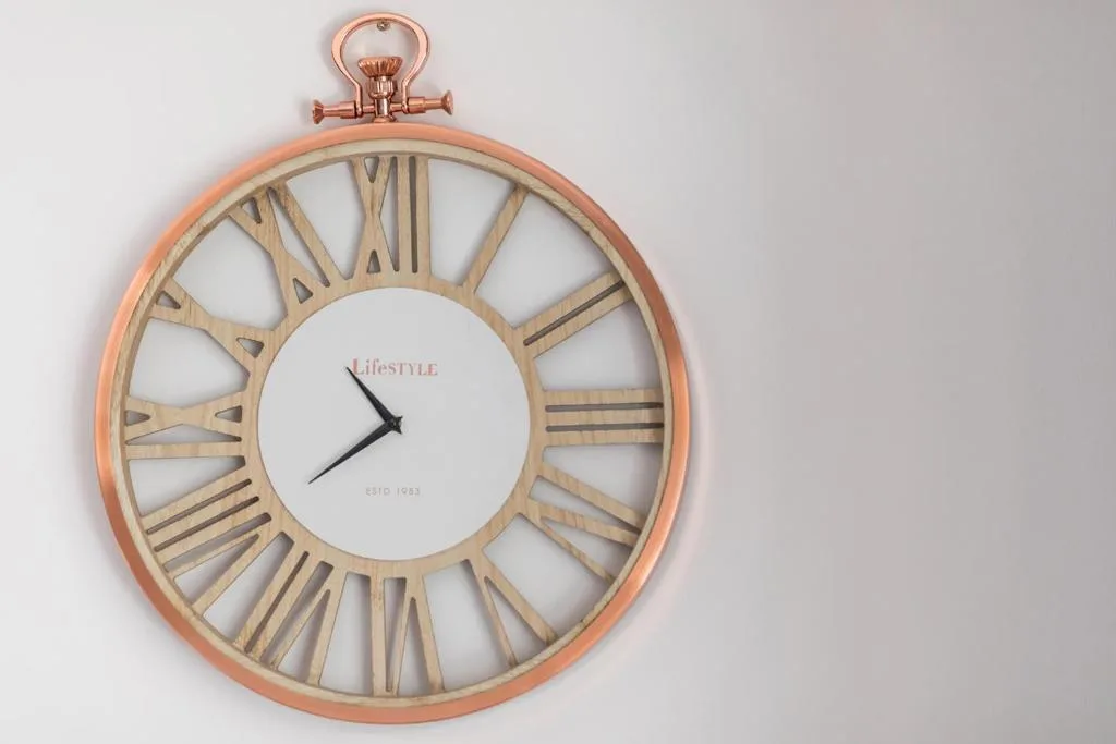 Decorative copper wall clock with Roman numerals and vintage style