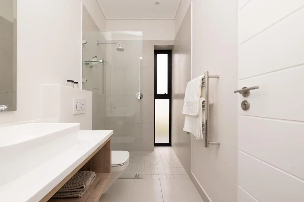 Modern bathroom with double vanity, walk-in shower, and heated towel rail