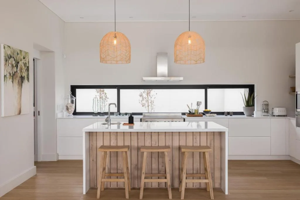 Modern kitchen with white cabinetry, wooden island, pendant lights, and bar seating