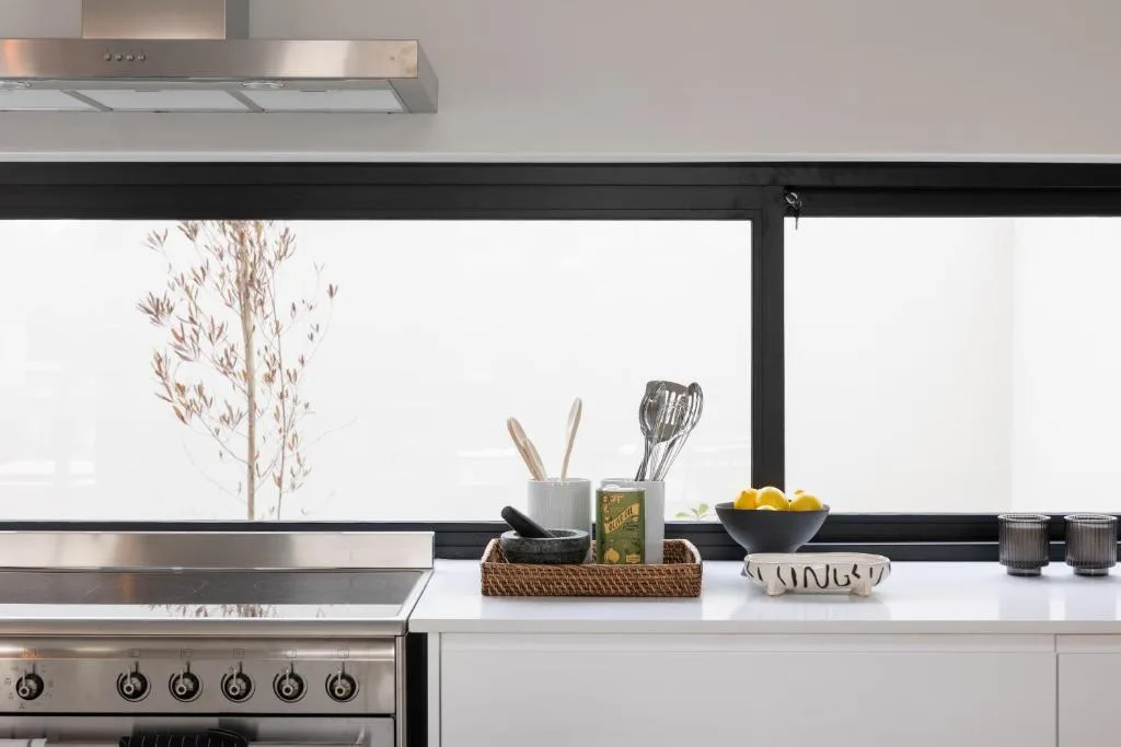 Modern kitchen counter with stainless steel range hood and stove