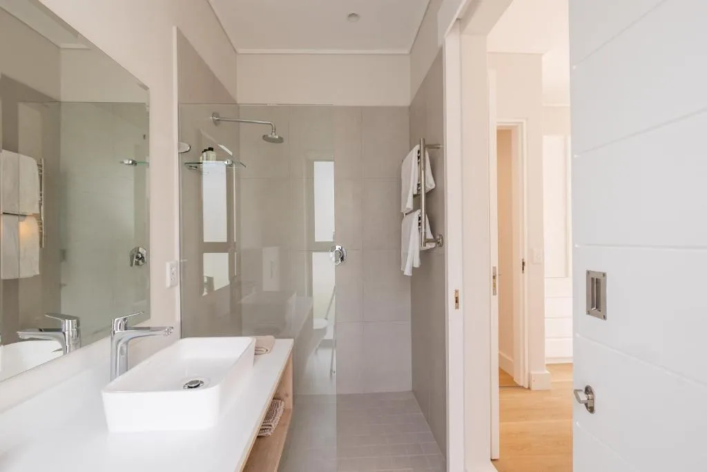Modern bathroom with double vanity sink and walk-in shower enclosure