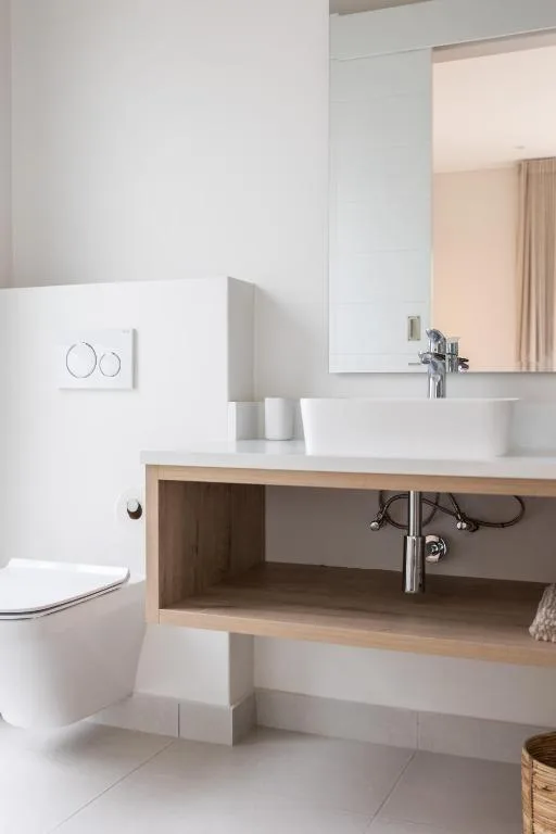 Modern bathroom with white basin sink and wooden vanity storage