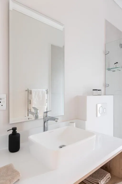 Modern white bathroom with vanity sink and illuminated mirror
