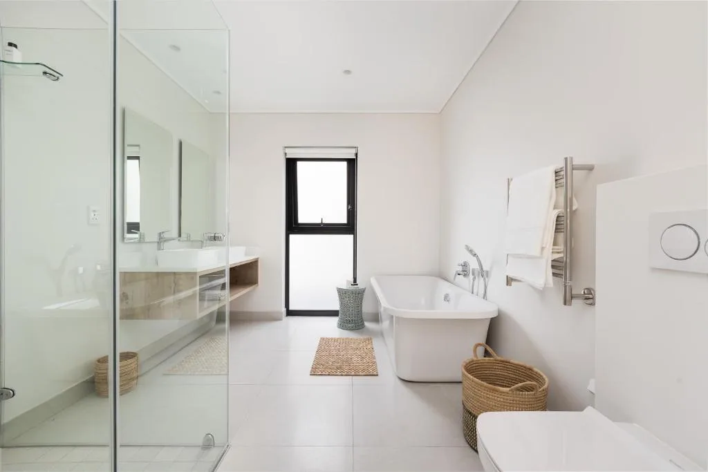 Modern bathroom with freestanding tub, walk-in shower, and natural light from window