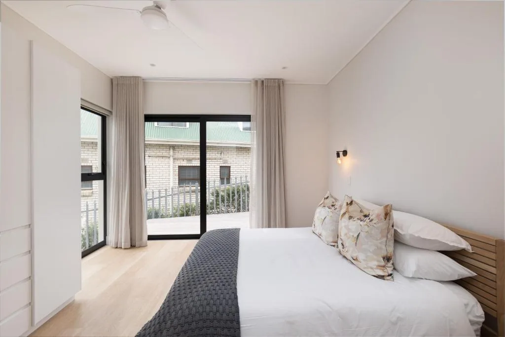 Modern bedroom with queen bed, sliding glass doors to private deck area