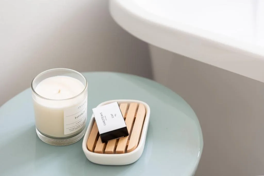 Scented candle and artisan soap on bathroom vanity table