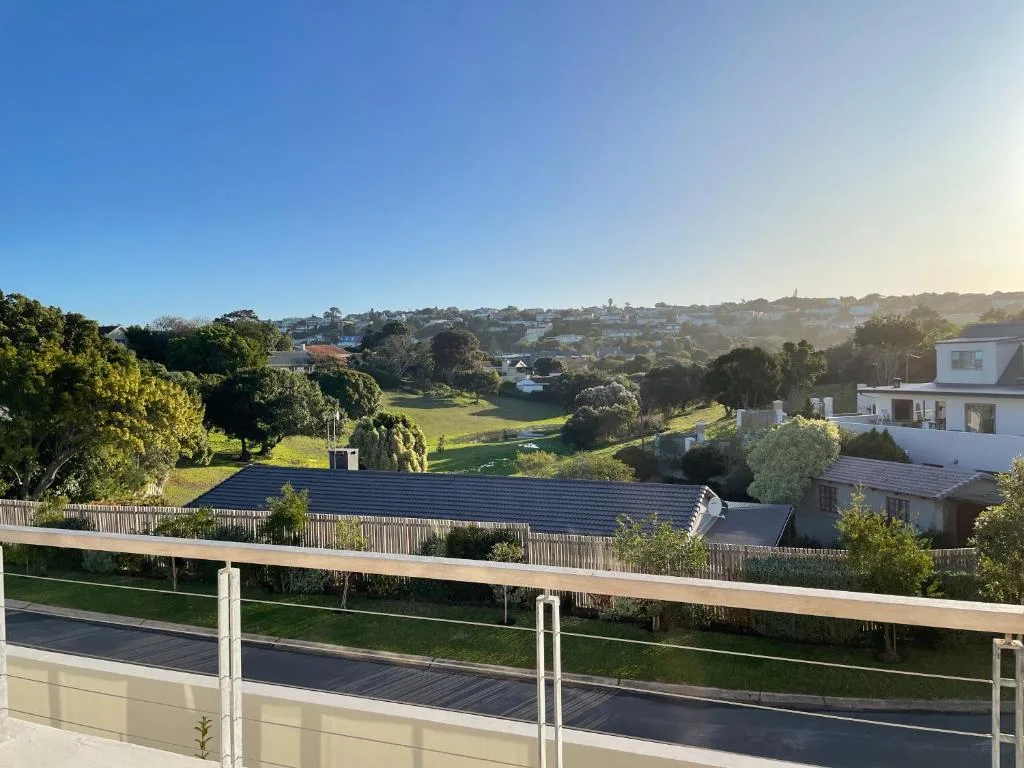 Expansive valley and town vista from elevated deck with green landscaping