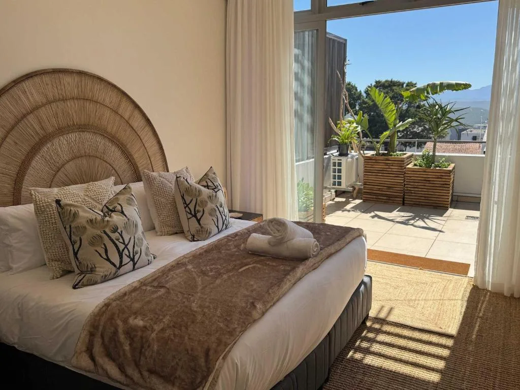 Bedroom with woven headboard, decorative pillows, and mountain view access