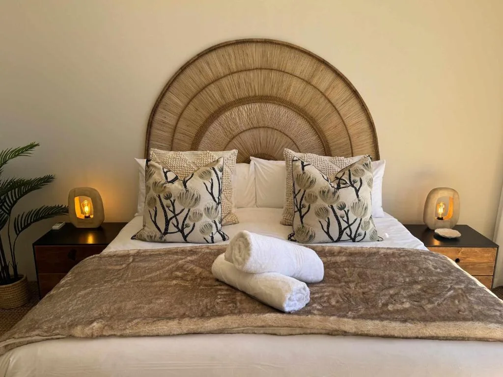 Elegantly styled bedroom with woven rattan headboard and decorative pillows