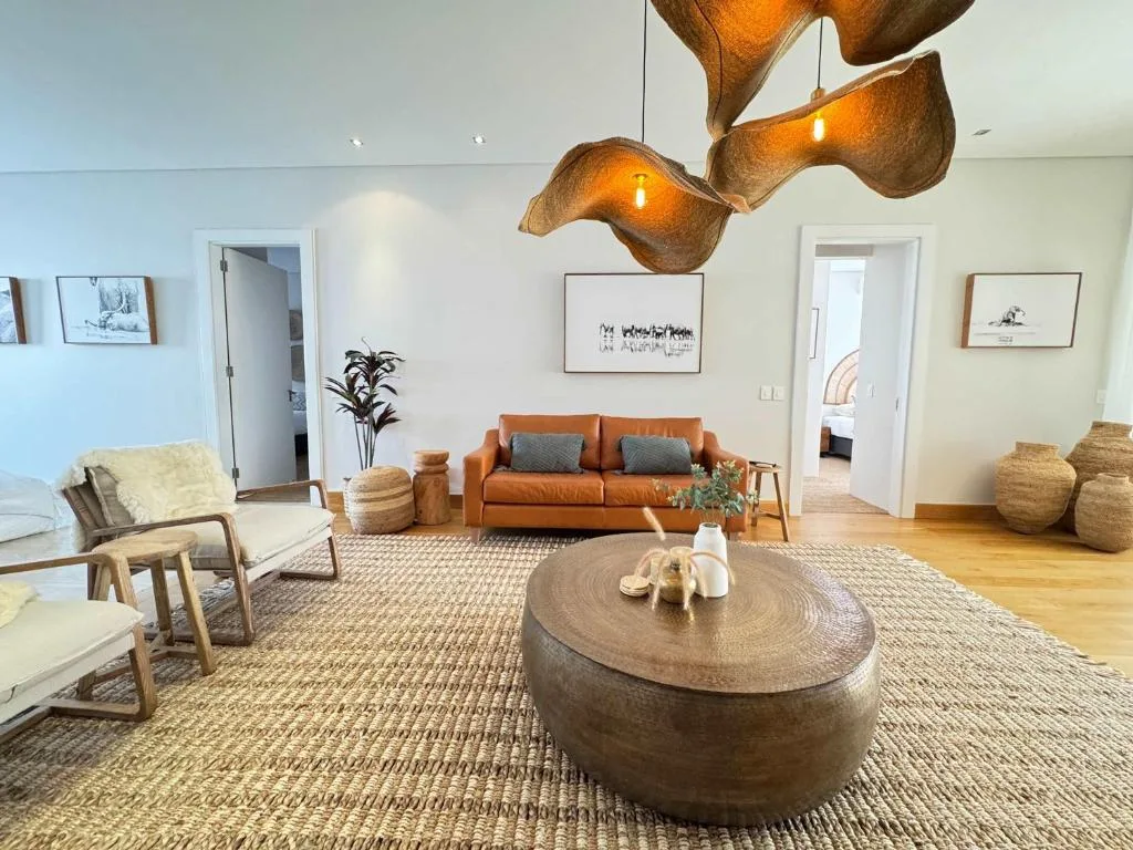 Modern lounge with orange sofa, wooden coffee table, and artistic pendant lighting
