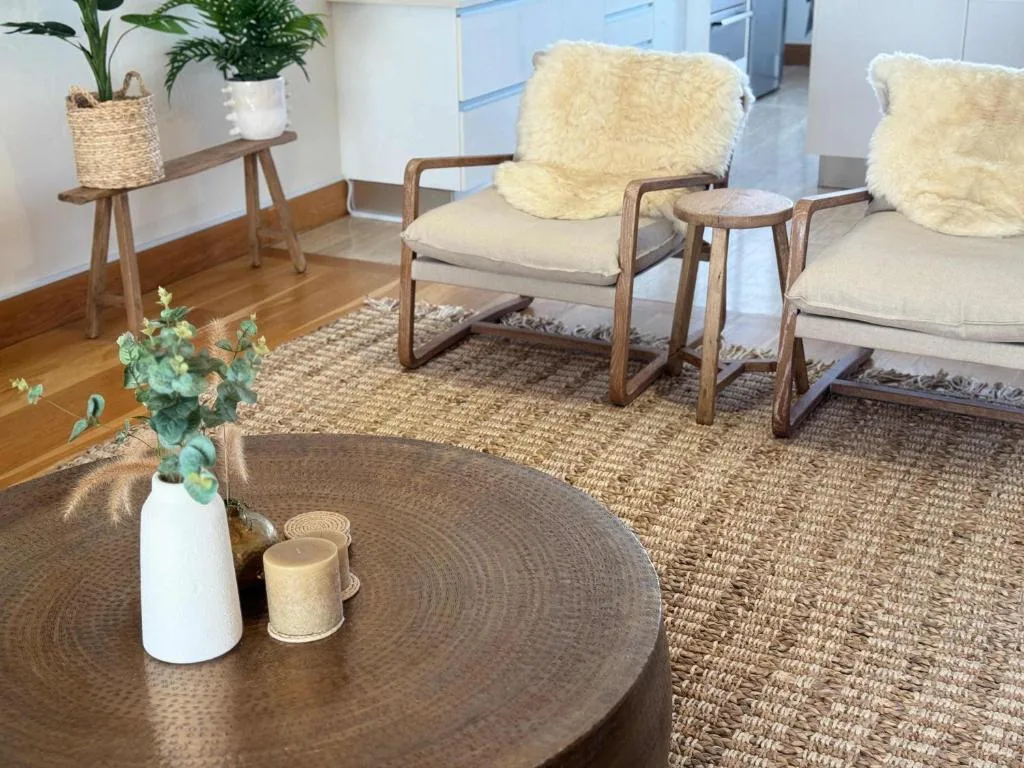 Contemporary lounge with wooden chairs, plants, and round coffee table