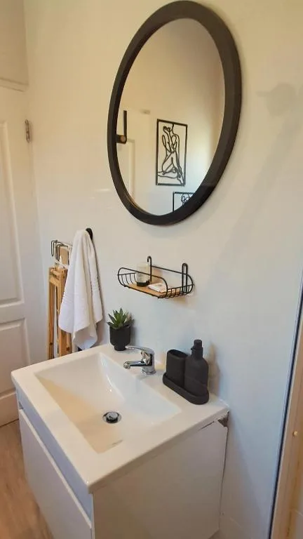 Modern bathroom vanity with round mirror and wall-mounted accessories