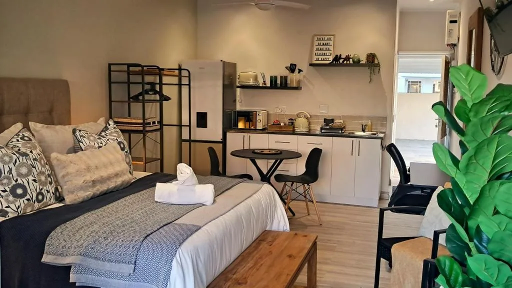Modern studio bedroom with comfortable bed, kitchenette, and contemporary furnishings