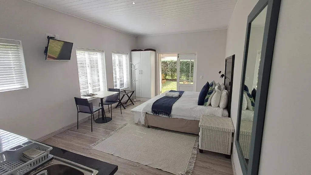 Spacious bedroom with queen bed, work desk, and garden view doors