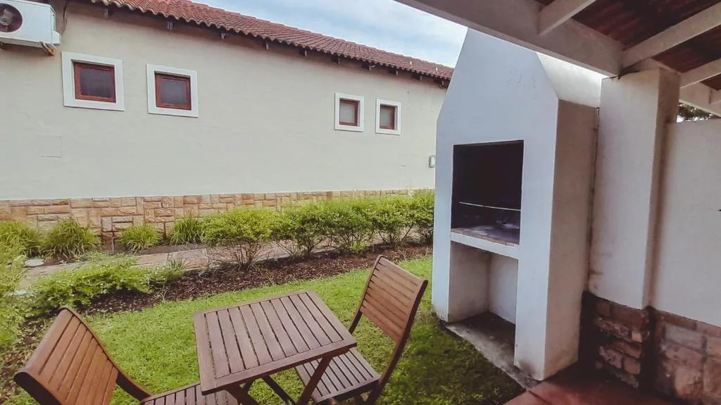 Outdoor seating area with wooden table and chairs on manicured lawn