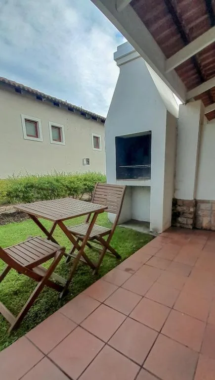 Wooden outdoor seating area with terracotta patio and manicured garden