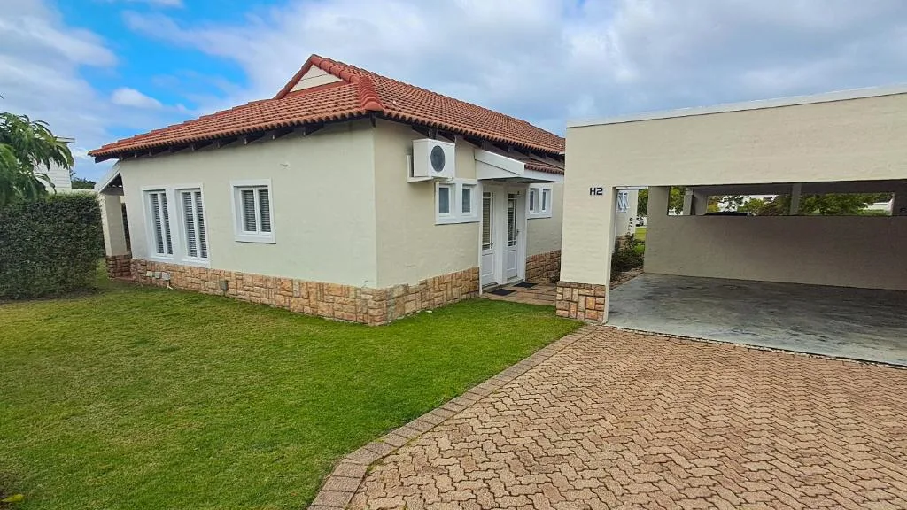 Modern cream and brick cottage with terracotta roof and attached garage