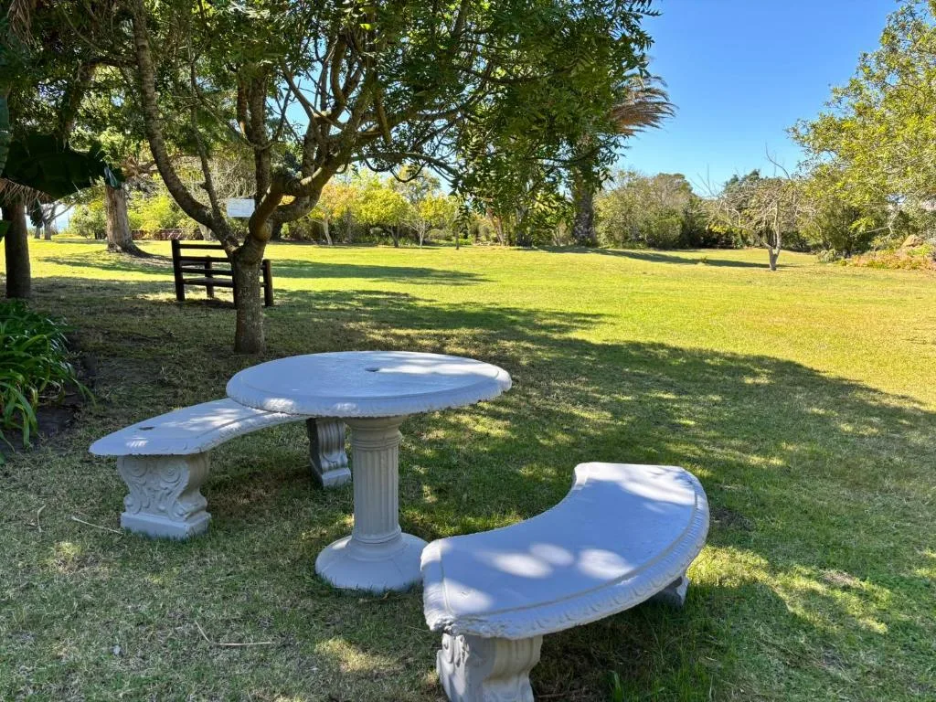 Decorative stone table and bench seating in manicured garden grounds