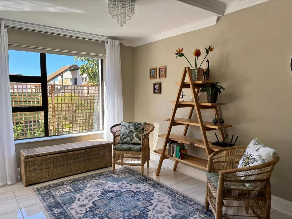 Bright lounge with wicker furniture, decorative ladder shelf, and window seating area