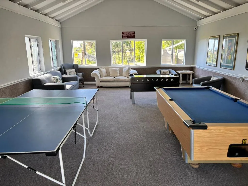 Spacious games room with pool table, ping pong, sofas and garden views