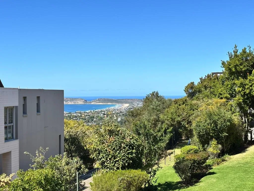 Coastal lagoon vista with blue ocean, white sand beach, and lush green vegetation
