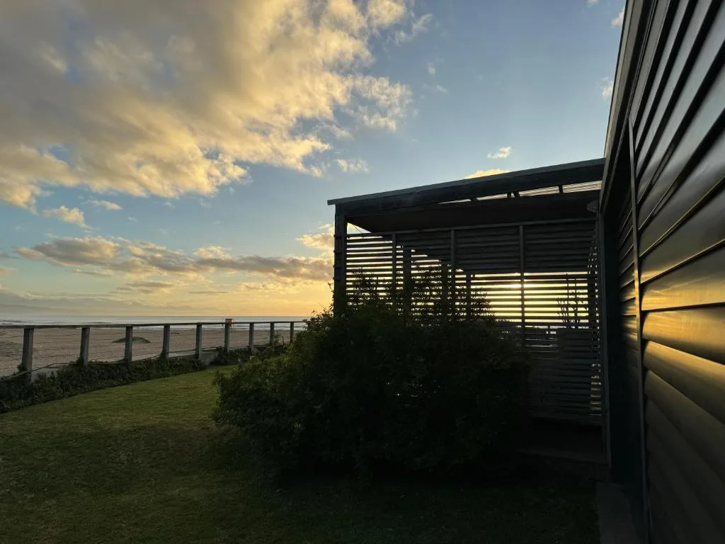Modern pergola with slatted roof overlooking tranquil lagoon waters
