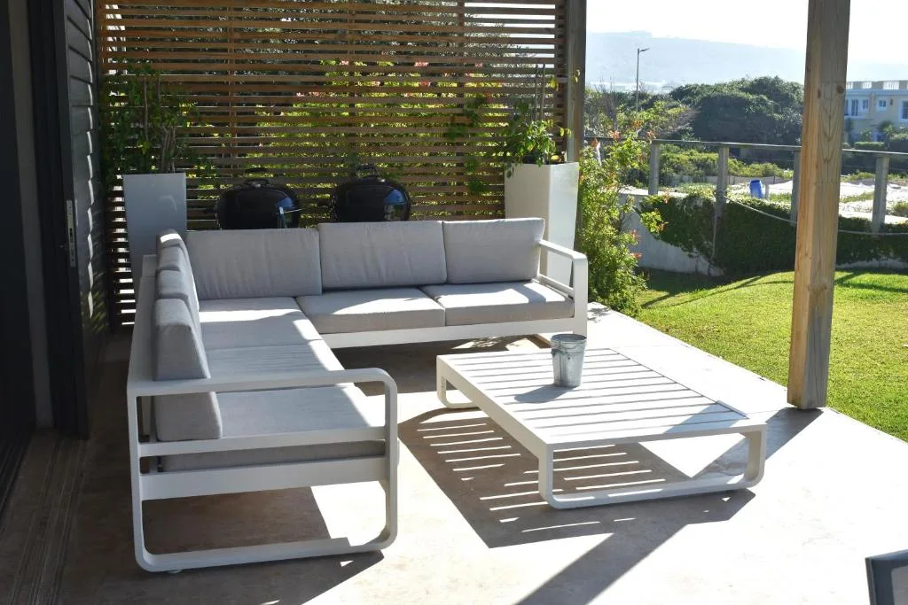 Modern outdoor seating area with comfortable lounge furniture and garden views