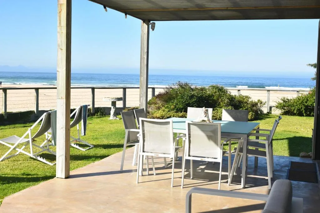 Beachfront patio with dining table and ocean view beyond