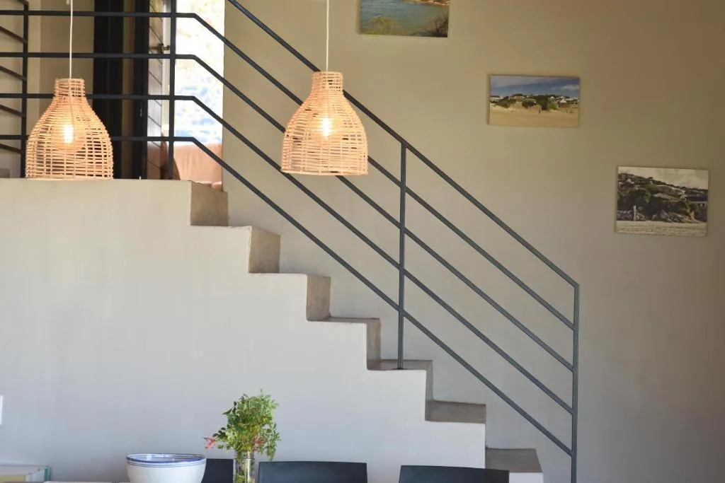 Modern staircase with woven pendant lights and local landscape artwork