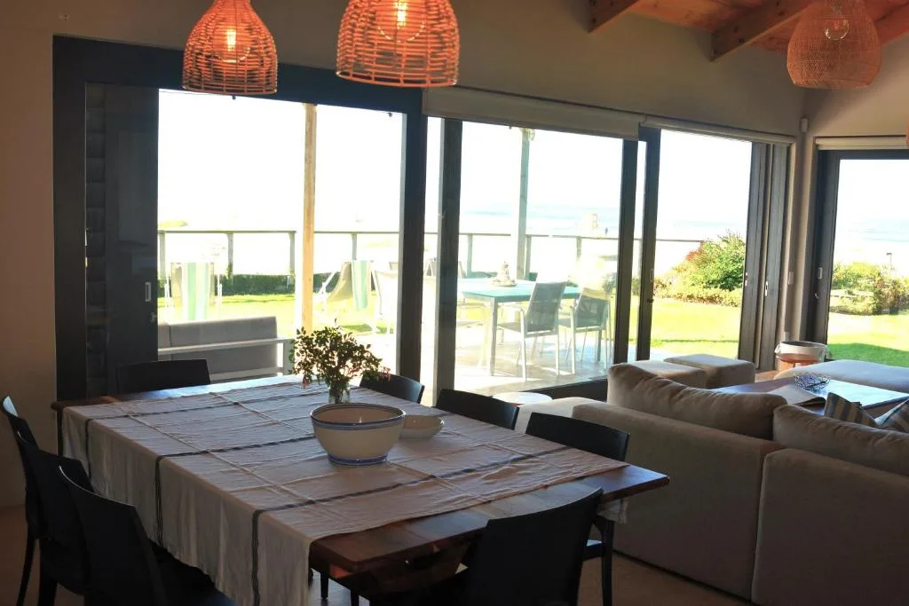Open-plan dining area with table, lounge seating, and garden views