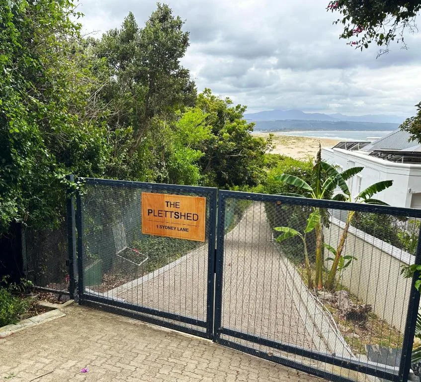 Property entrance gate with scenic coastal views and mountains beyond