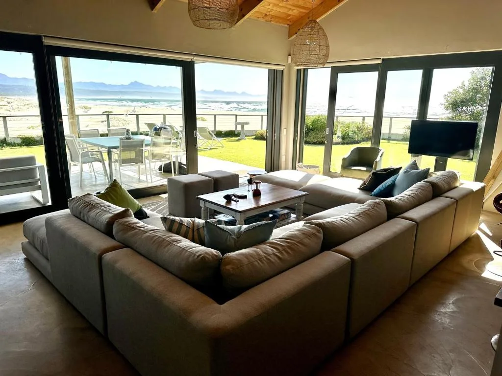 Spacious lounge with sectional sofa overlooking beach and mountains