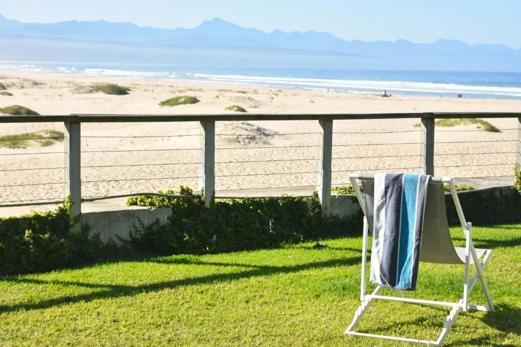 Expansive beach and mountain views from beachfront garden with towel rack