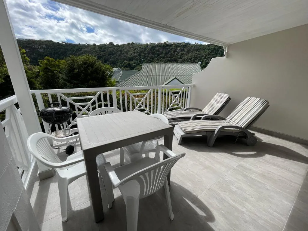 Spacious deck with lounge chairs, dining table, and lagoon views