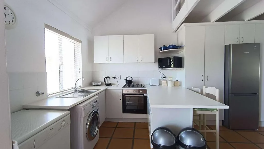 Modern kitchen with white cabinetry, stainless steel appliances, and island counter